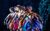 Beauty and the Beast Dancers in colourful costumes standing in the same pose in a row.