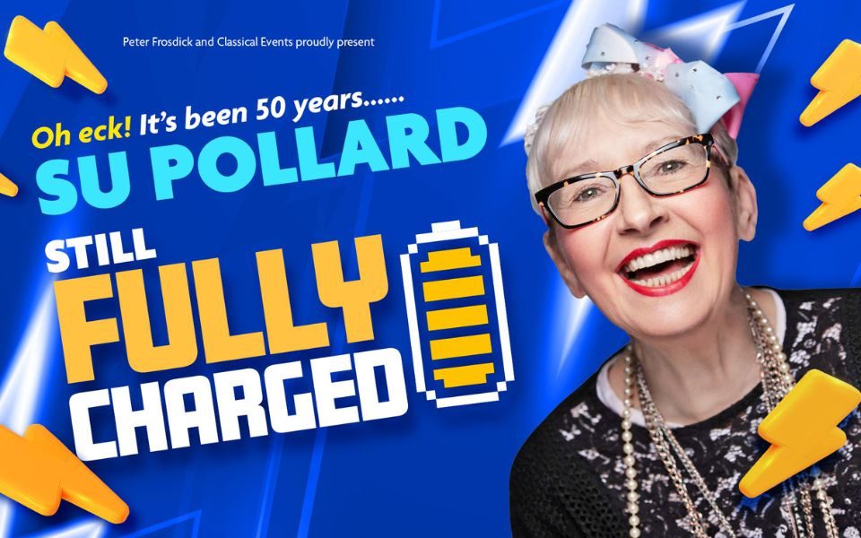 Su Pollard wearing glasses, a pale pink and blue bow in her hair and a black lace jumper with long necklaces against a blue background. Text reads proudly present. Oh eck! It's been fifty years... Su Pollard Still Fully Charged. Text is surrounded by plastic-looking lightening bolts and a full battery icon.