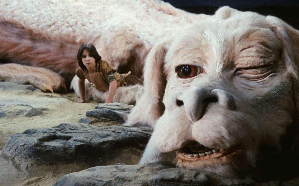 Long-haired Noah Hathaway as Atreyu with Falkor the white fluffy Luck Dragon in the universe. Falkor has his left eye closed.
