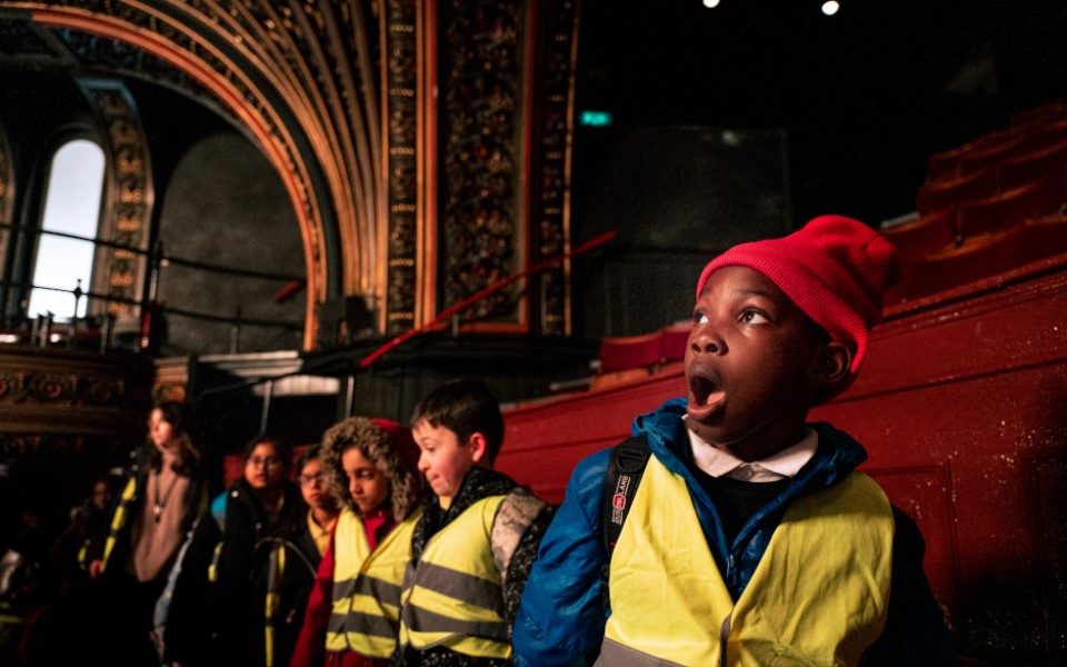 A group of primary schoolchildren on a tour at Leeds Grand Theatre