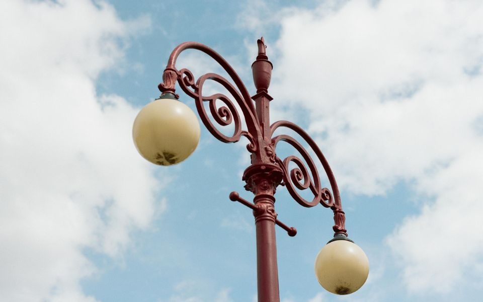 Iconic red lamppost of Hyde Park Picture House again the pale blue sky and some white clouds.