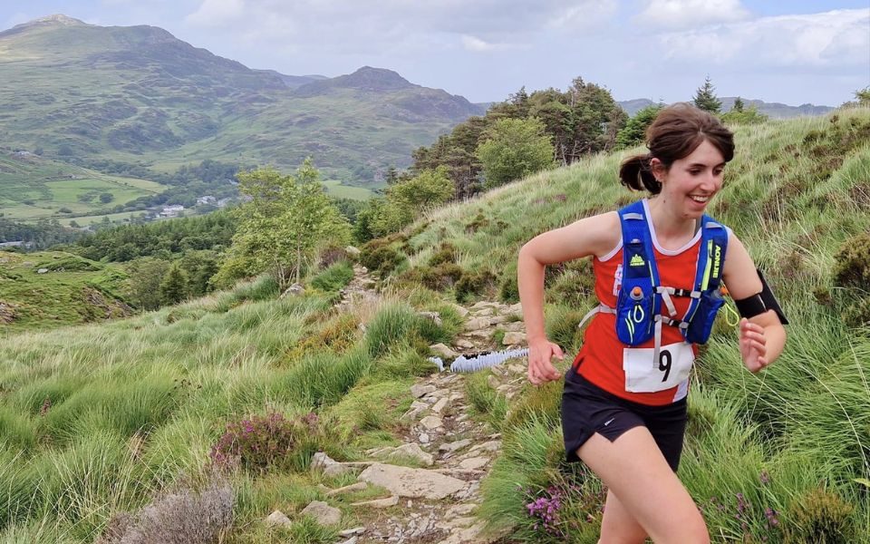 Sarah running up a grassy mountainous hill