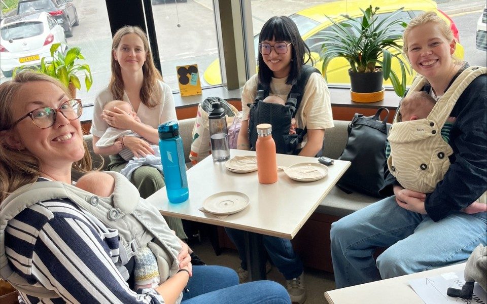 Four mothers holding or cradling babies sat around one of the tables in the Hyde Park Picture House's Café Bar.