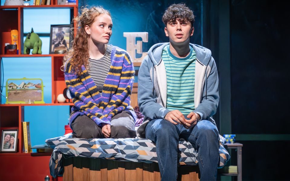 Sonny Monaghan (Evan Hansen) and Lauren Conroy (Zoe Murphy) sat next to each other on a bed.