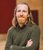 Sam Kenyon. Credit Sam Allard A bearded man with shoulder-length hair and in a green jumper, Sam Kenyon, poses with arms crossed for a headshot