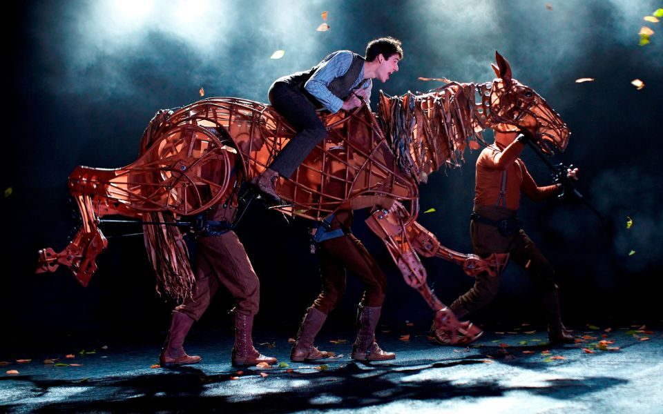 An actor riding a lifesize puppeteered horse.