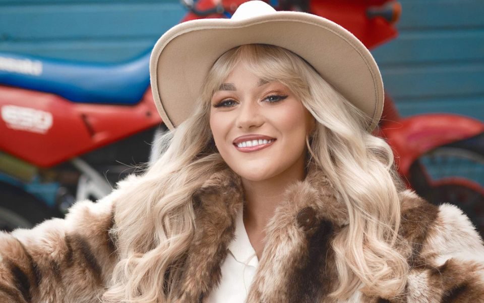 Claudia Buckley wearing a beige cowboy hat and a fur coat.