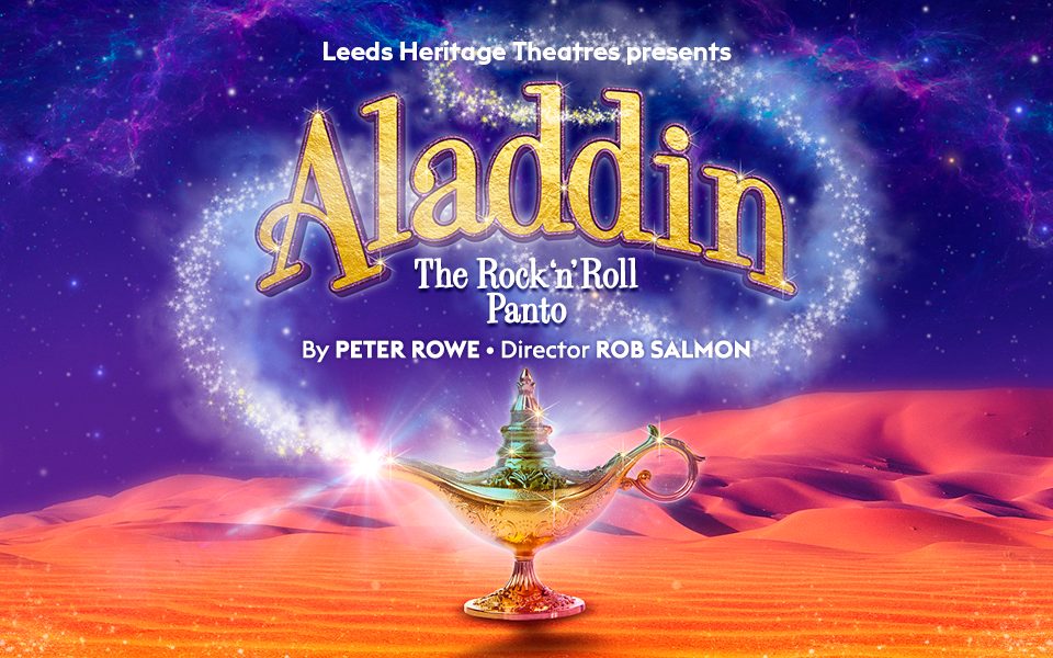 A bright orange desert with sand dunes with a genie lamp in the foreground that has sparkles coming out of its spout. Text reads: Leeds Heritage Theatres presents Aladdin: The Rock 'n' Roll Panto. By Peter Rowe. Director: Rob Salmon. Above the sand dunes is a night sky filled with stars and galaxies.