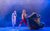 Northern Ballet's A Christmas Carol A dancer dressed in a old nightshirt as Scrooge stands watching a dancer dressed in red trousers and a long green cape adorned with ivy and greenery. The cape floats out dramatically as he walks across the stage.