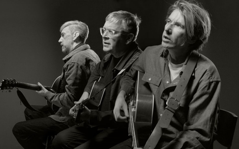 Black and white image of Norman Blake, Bernard Butler and James Grant playing guitars and singing.