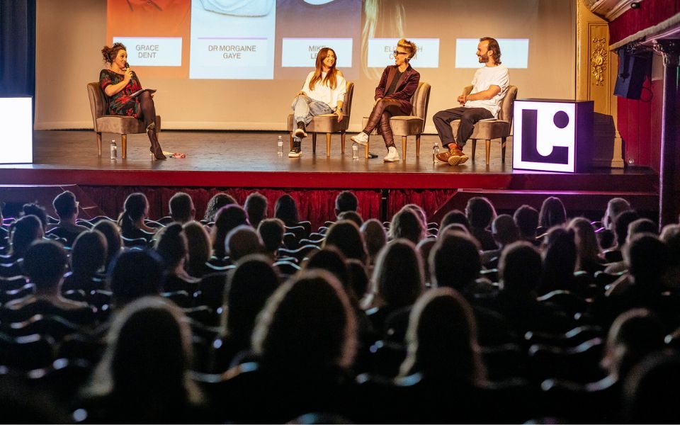 Four speakers at the Leeds International Festival of Ideas 2021 event Have We Got Enough Food? sat on nice chairs on stage with the silhouettes of the backs of the heads of the audience in the stalls blurred in the foreground.