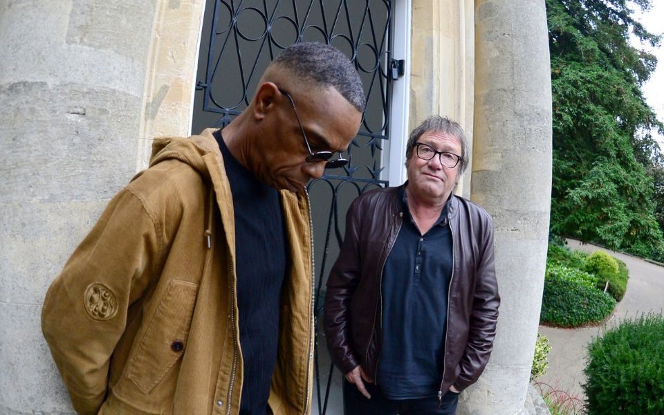 Simon Fowler and Oscar Harrison of Ocean Colour Scheme stood in front of an old-looking iron door.