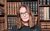 Susie Dent Susie Dent wearing glasses in front of a book case.