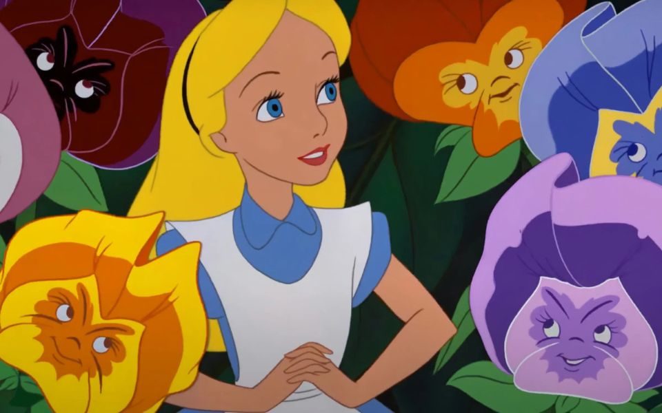 Still from Alice and Wonderland of Alice surrounded by plants with faces.
