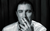 Tom Rosenthal Black and white image of Tom Rosenthal smoking in the style of the Arctic Monkeys' album cover for Whatever People Say I Am, That's What I'm Not.