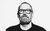 Boo Hewerdine Black and white headshot image of Boo Hewerdine looking straight on at the camera wearing a bomber jacket, tshirt and glasses.