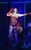 Frank-N-Furter Frank-N-Furter in Rocky Horror Show wearing a red corset, red gloves, fishnets, suspenders and heels, singing into a microphone.