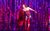 Frank-N-Furter Frank-N-Furter in Rocky Horror Show wearing a red corset, red gloves, fishnets, suspenders and heels, singing into a microphone and holding a red feather boa. Behind them is the cast in a line wearing corsets and large feather boas.