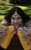 Satnam Galsian Satnam Galsian in a patterned yellow dress leaning on a wooden box.
