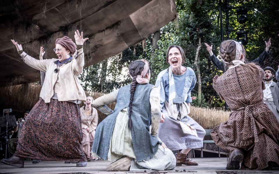 Ensemble cheering and dancing joyfully on an open air stage