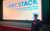 Ben at Short Stack Ben posing in front of a screen that reads Welcome to Short Stack showcasing the best short films from the Midlands