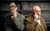 Holmes and Watson Peter Clifford and the Great Baldini portray a suited Holmes and Watson. They each look through a magnifying glass with comic intensity in an old-fashioned room.