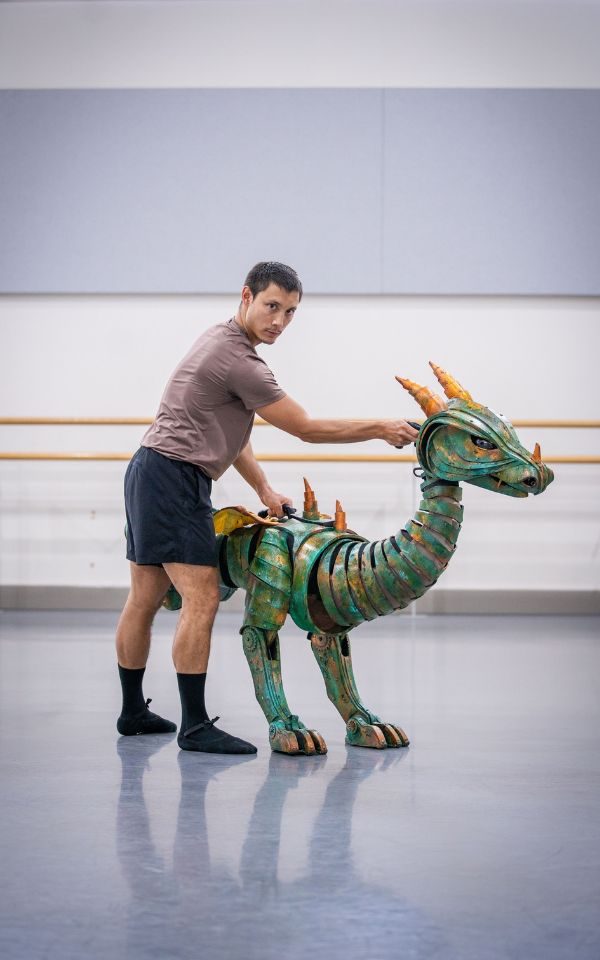 Kevin Poeung stands alongside the dragon puppet in a rehearsal studio.