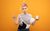 Hannah East Hannah East stands sighing and exasperated with a messy bun, her arms outstretched holding a prosecco flute with a dummy floating in it, and a tub of Sudocrem. Her shirt is stained and a breast milk pump is on display.