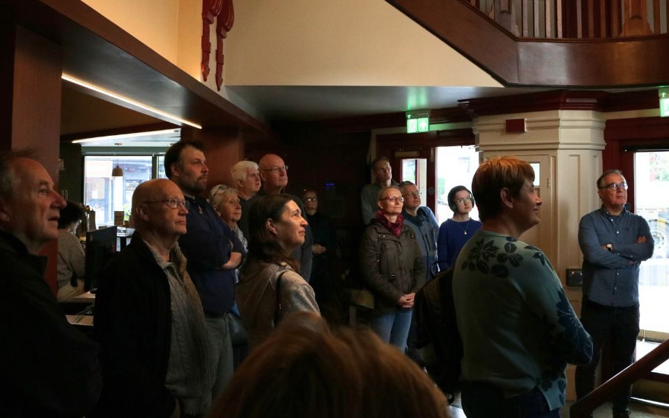 A crowd of people listen to a talk in the Hyde Park Picture House foyer