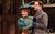 Kerry Ellis dressed in a blue Victorian-style dress and hat, holding hands with Peter Sandys-Clarke dressed in a Victorian striped grey suit in The Importance of Being Earnest.