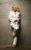 Kerry Ellis Kerry Ellis wearing a white pantsuit and leaning against a beige wall with one foot up on the wall behind her.