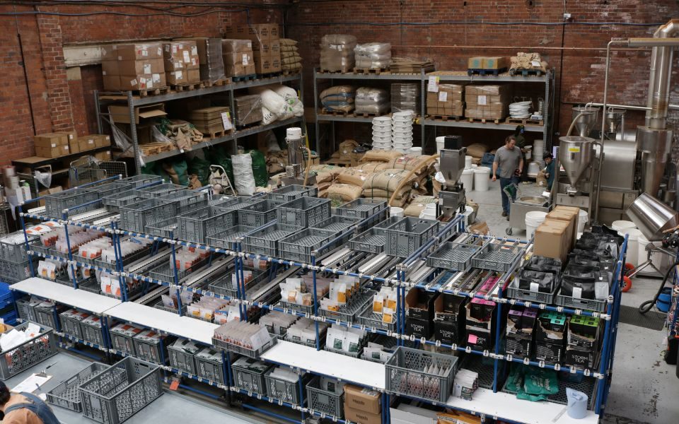 A warehouse containing shelving and sacks of coffee