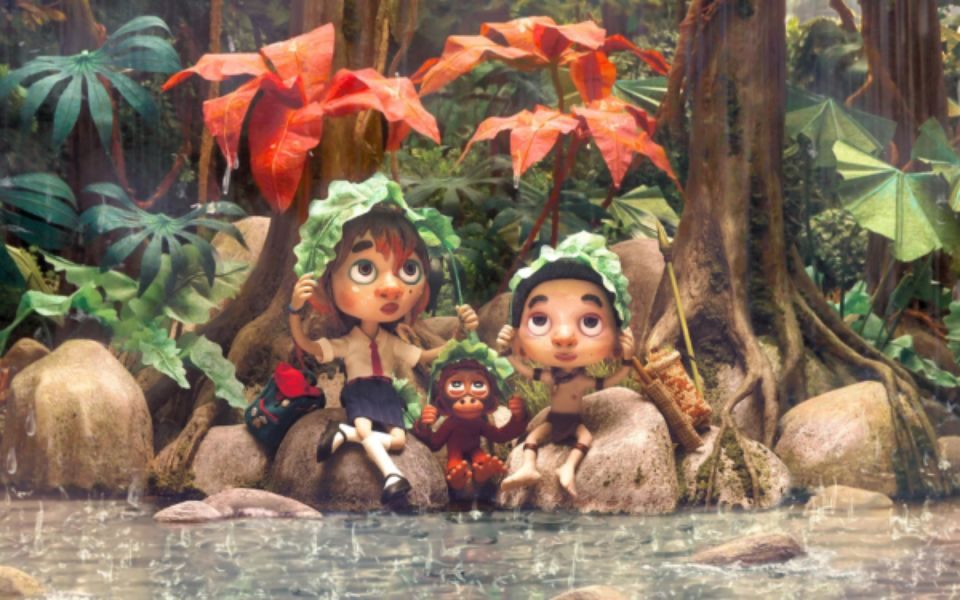 Two animated children and a monkey sit on rocks by some open water. They are covering their heads with leaves and looking up at the rain.
