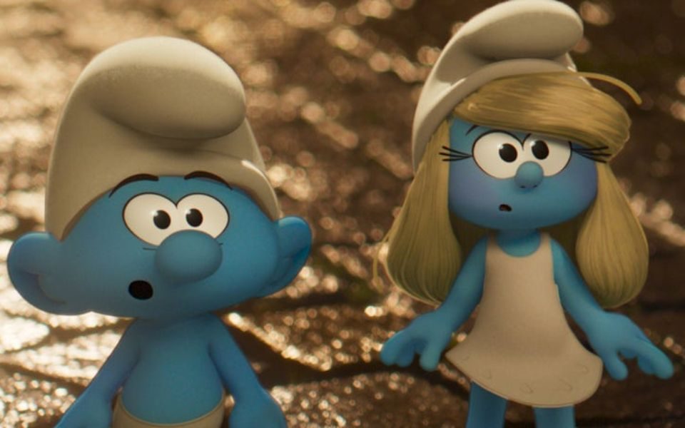 Two animated blue Smurfs in white robes and caps stand shocked on a wet cobbled street.