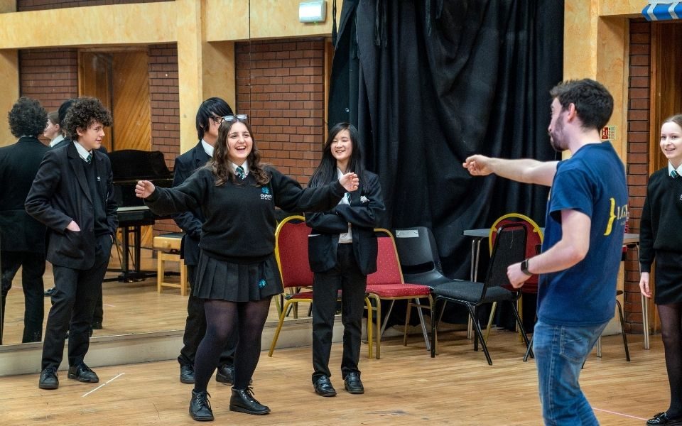Ashley points to a group of students performing in a studio