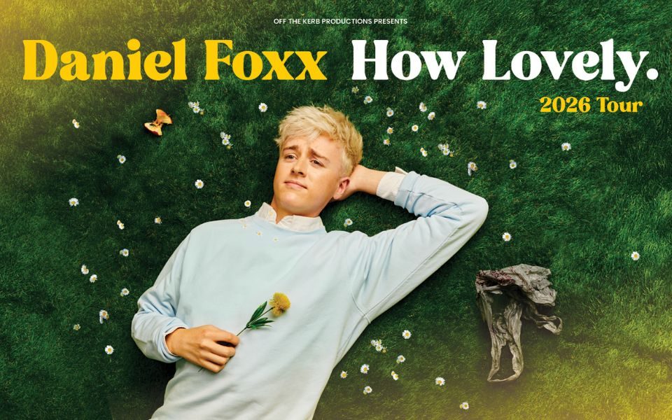 Daniel Foxx lies on a bed of soft grass and gazes at the sky, surrounded by daisies and holding a flower. Text reads: Off the Kerb Productions Presents Daniel Foxx How Lovely. 2026 Tour.