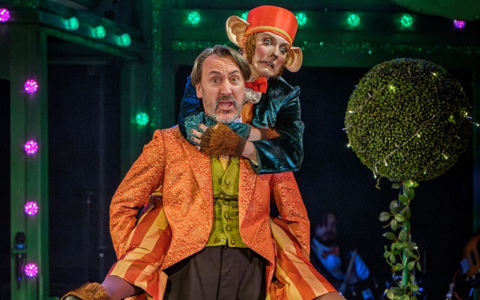 Maddie Hansen as Muddles the Monkey on the back of Dan Carter Hope (Emperor) in Aladdin: The Rock n Roll Panto.