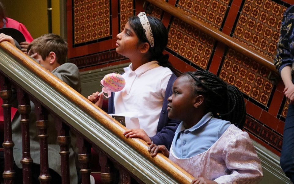 Two students stand along the stairwell in The Grand Theatre.