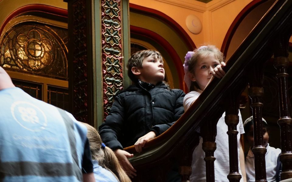 Two students stand along the stairwell in The Grand Theatre.