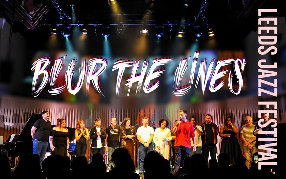 Wearing a red t-shirt, Lence speaks into a microphone in front of a line of performers on stage. Text reads Lence presents... Blur The Lines. Leeds Jazz Festival.