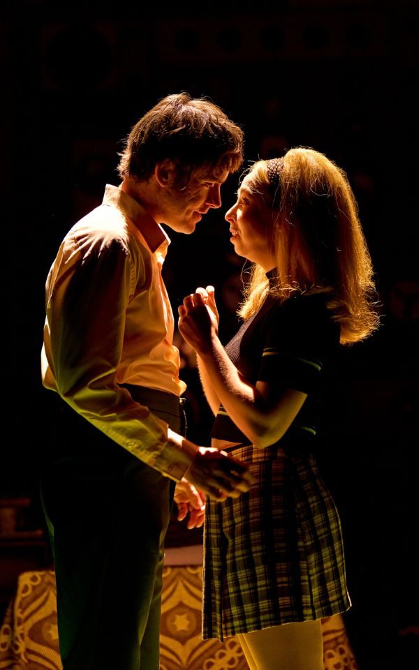 A man and woman staring intimately at each other in moody lighting.