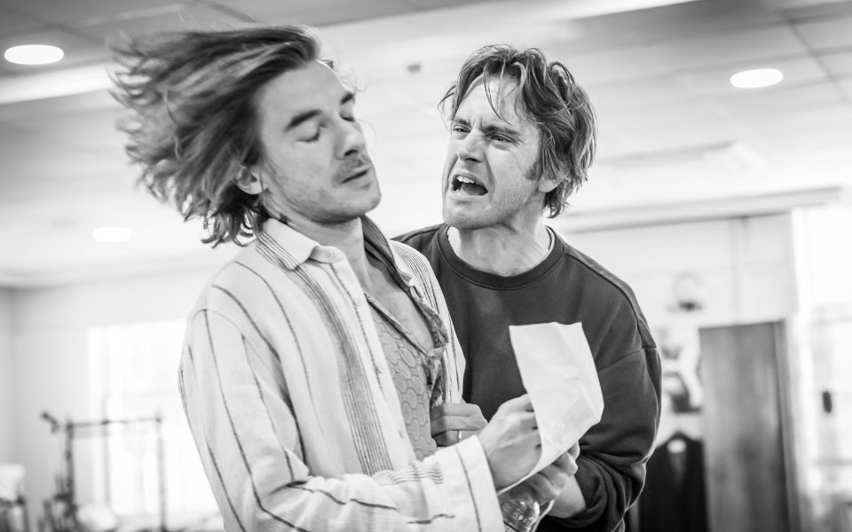 A black and white photo of an actor shouting at another actor in rehearsals for Sunny Afternoon.