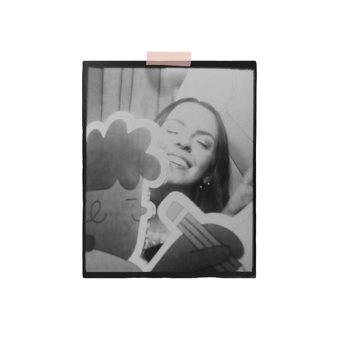 Black and white polaroid image of Hollie Fuller smiling behind an illustrated character.