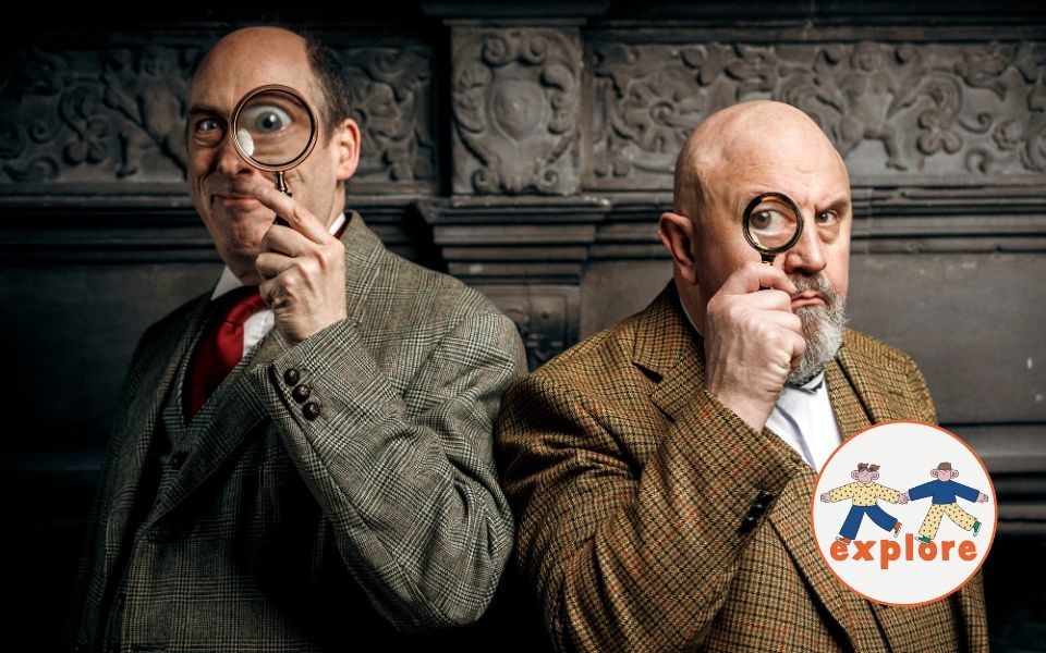 Peter Clifford and the Great Baldini portray a suited Holmes and Watson. They each look through a magnifying glass with comic intensity in an old-fashioned room. In the bottom right corner, a roundel featuring a playful illustration of two people running across the word 'explore'.
