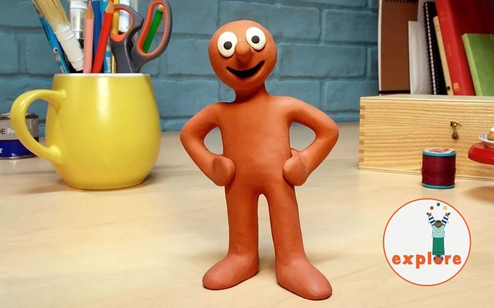 Plasticine character Morph, stood smiling on a desk. In the bottom right corner, a roundel featuring a playful illustration of a person juggling stood on the word 'explore'.