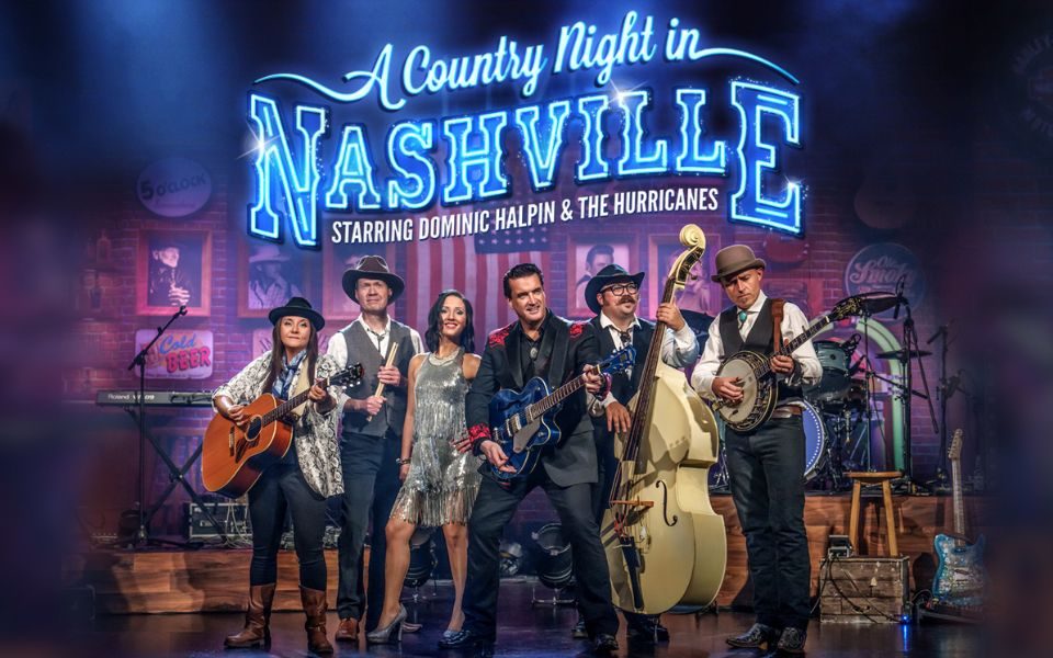 The members of A Country Night in Nashville stand together on stage in period costume, each holding their guitar or instrument. American memorabilia, photographs and flags are visible in the background, behind electric blue text reading: A Country Night in Nashville. Starring Dominic Halpin and the Hurricanes.