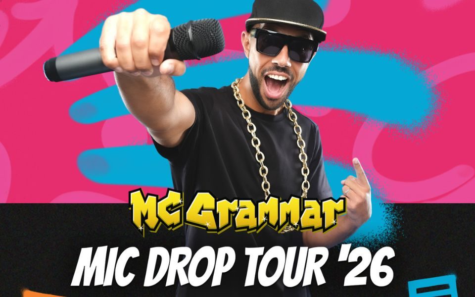 MC Grammar holds out a microphone in front of him, with a wide open-mouthed smile, wearing a black baseball cap, dark sunglasses and a thick chain, in front of a blue and pink graffiti background. Text reads: MC Grammar. Mic Drop Tour '26.