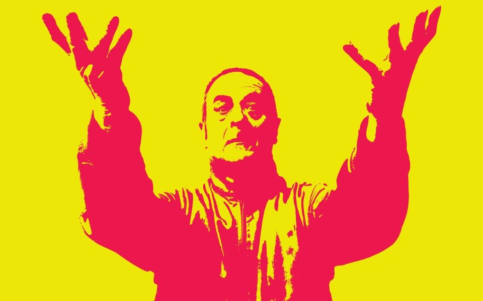Red and yellow stylised image of Mark Thomas in a jacket with two extended arms held up to the camera.
