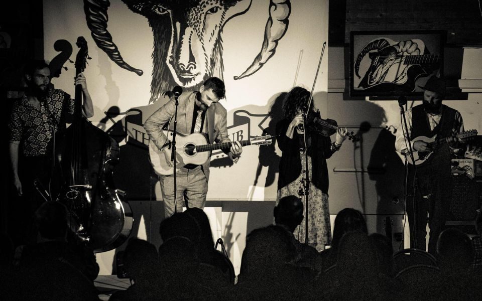 The Frank Burkitt Band performing on stage in a black and white image