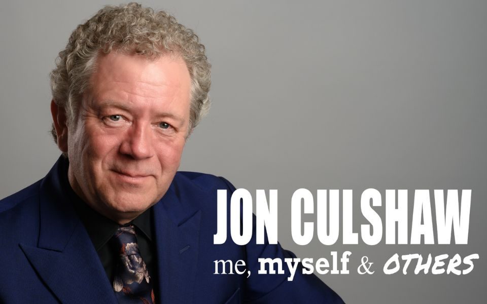 Jon Culshaw smiles in a navy blue suit and dark patterned tie. Text reads: Jon Culshaw: Me, Myself and Others.